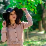 Stylish woman wearing a hat in a sunny İstanbul park, fashion pose.